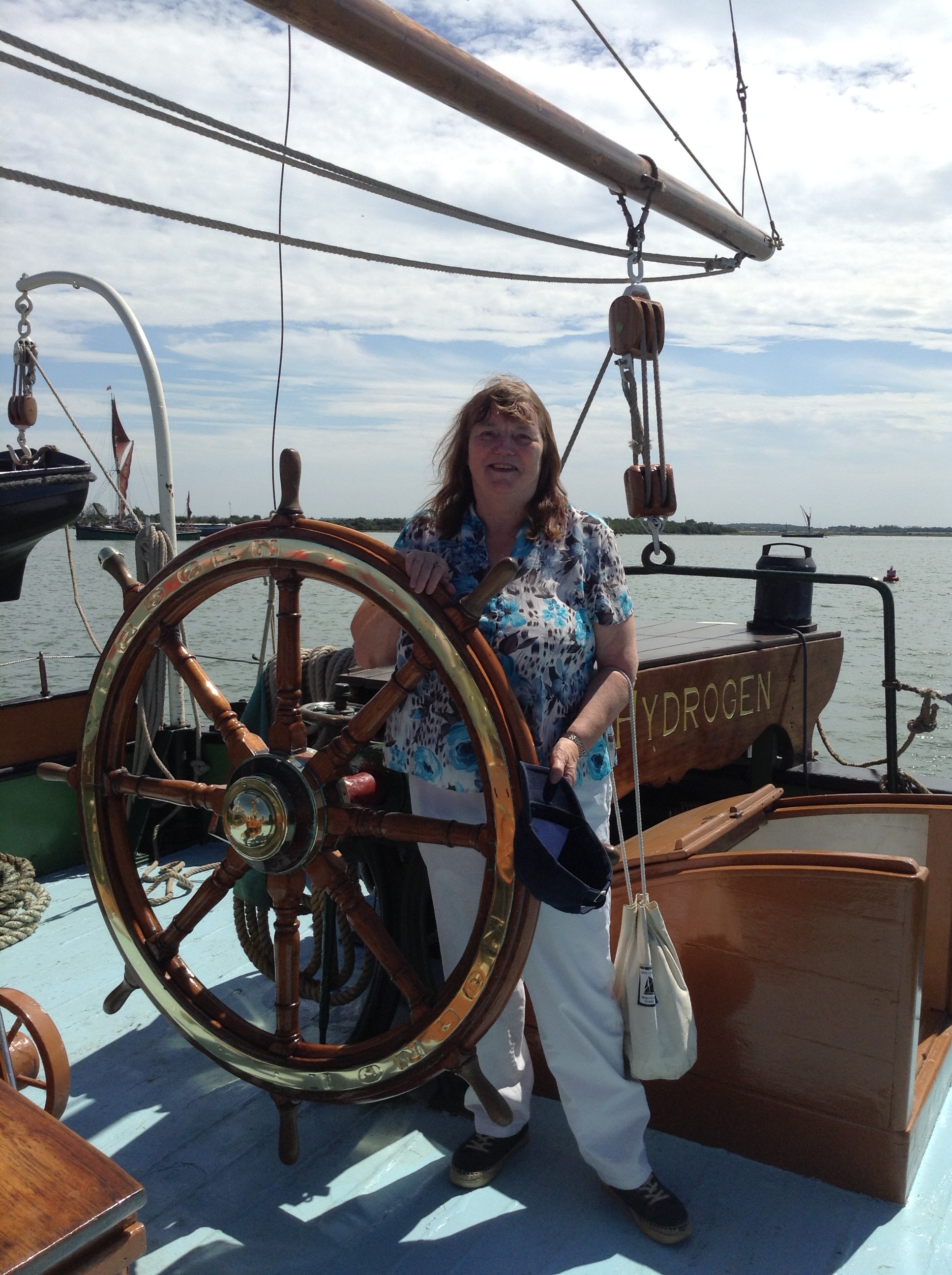 women driving boat by at ships wheel